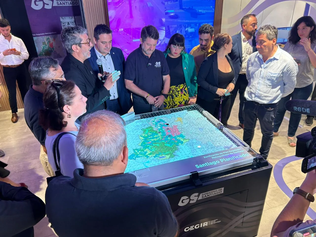 CEGIR demo session — group gathered around the tactile Santiago table with CEGIR-branded presenters