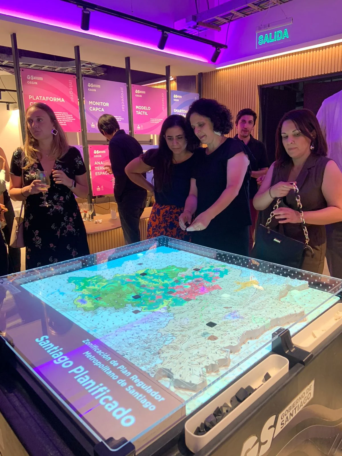 Workshop around the tactile table analyzing the Plan Regulador Metropolitano de Santiago, with four participants.